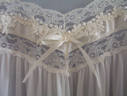 Lace appliqué and bow at the bust-line of a nightgown.