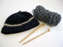 Knit hat, yarn, and knitting needles.