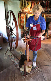 Spinning wheel demonstration in the Conner Prairie living history museum loom house, producing yarn from wool.
